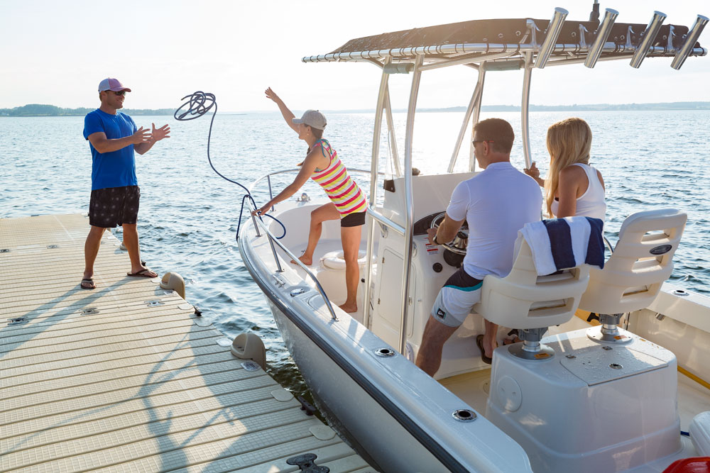 Woman tossing rope to man to anchor boat